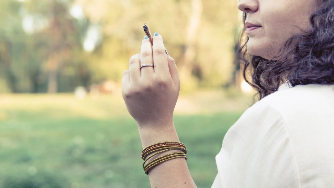 woman smoking a blunt or joint of marijuana