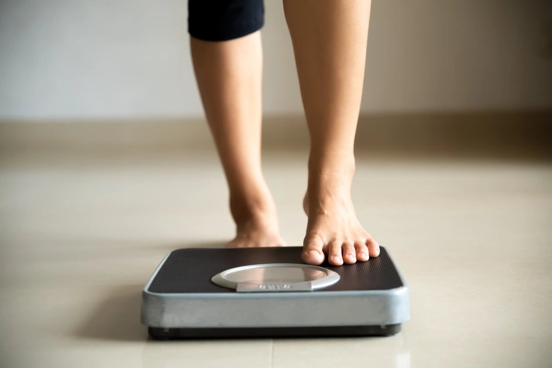 woman stepping onto a weight scale