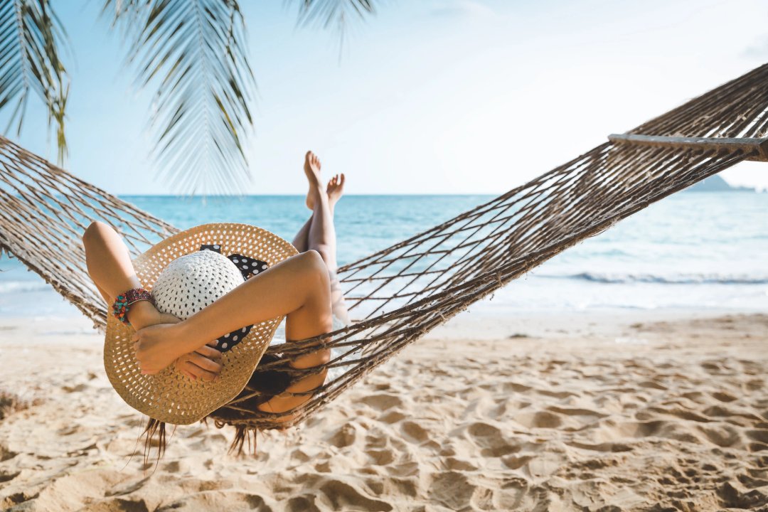 woman relaxing on the beach on a hammock