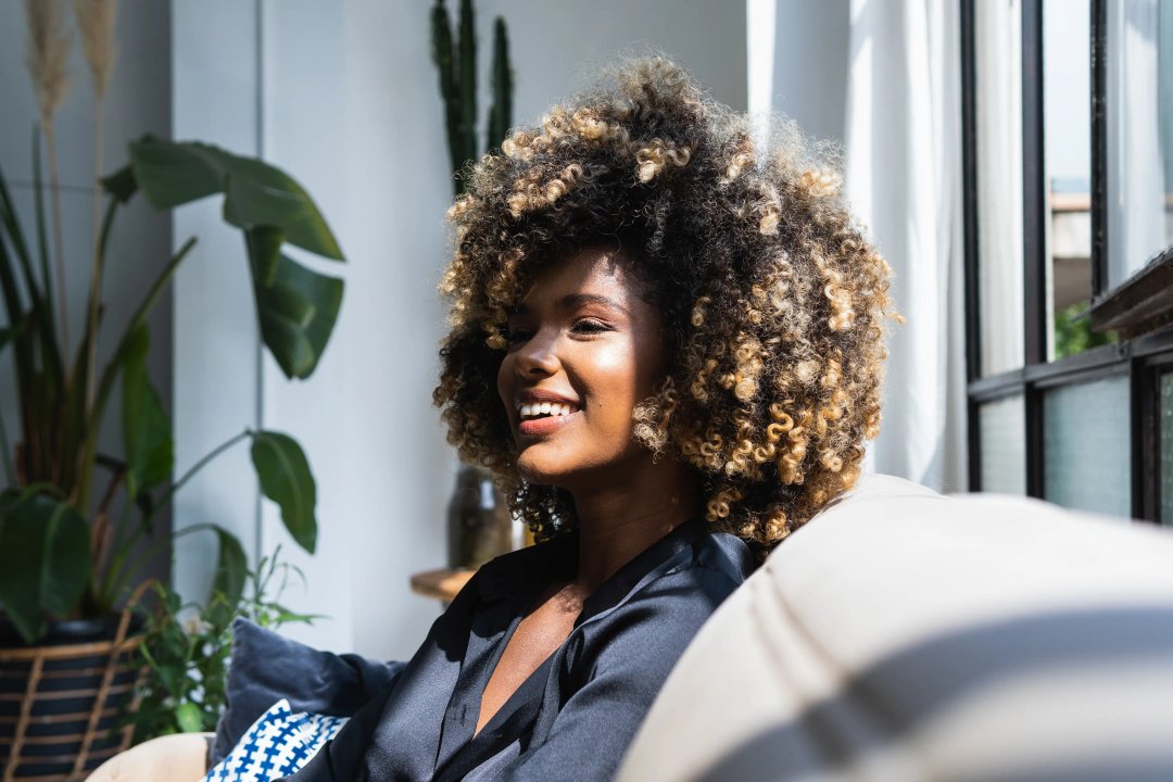 beautiful african american woman smiling on the couch, high during the daytime